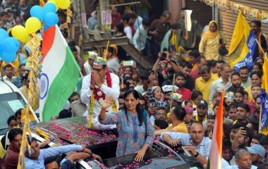 Sunita Kejriwal, wife of Delhi CM Arvind Kejriwal, greets the crowd during the roadshow for the upcoming Lok Sabha Elections, at village Deoli near Sangam Vihar, on May 5, 2024 in New Delhi, India.  clipart