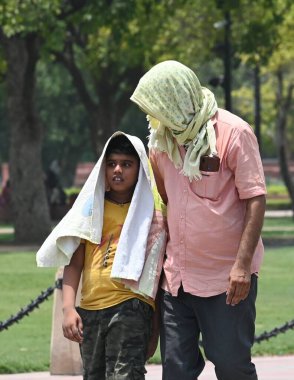 NEW DELHI, INDIA - 20 Mayıs 2024: Sıcak yaz mevsiminde Yeni Delhi, Hindistan 'da 20 Mayıs 2024 tarihinde Kartvaya Yolu çimlerinde sıcak hava dalgasına göğüs geren ziyaretçiler. Hindistan Meteoroloji Bölümü (IMD) hava durumu raporunda şiddetli sıcak hava dalgası koşulları belirtiliyor