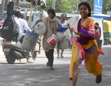 NEW DELHI, INDIA - 29 Mayıs 2024 'te Hindistan' ın Yeni Delhi kentindeki Sanjay Camp Chanakyapuri 'de yaz aylarında yaşanan bir su krizi sırasında, yerliler bir tankerden içme suyu alıyorlar. Artan sıcaklıkla Delhi büyük bir su kriziyle karşı karşıya.