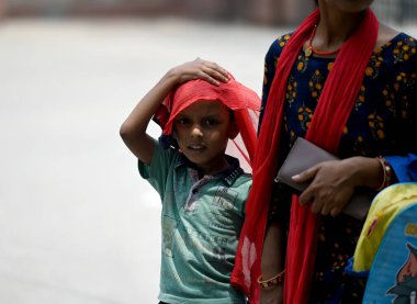 NOIDA, INDIA - 26 Mayıs 2024 Noida, Hindistan 'da kendilerini 30 Mayıs' taki sıcak yaz gününden korumak için başları örtülü gezginler. 