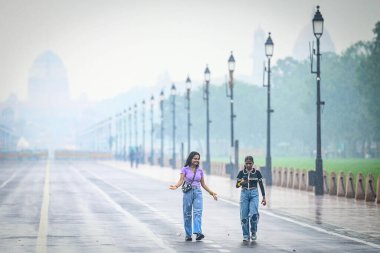 NEW DELHI, INDIA - 27 Temmuz 2024 'te Hindistan Kapısı' nda aniden yağan yağmurlar sırasında Yeni Delhi, Hindistan 'da insanlar görüldü..