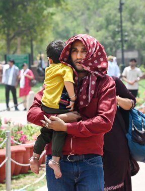 NEW DELHI, INDIA - 20 Mayıs 2024: Sıcak yaz mevsiminde Yeni Delhi, Hindistan 'da 20 Mayıs 2024 tarihinde Kartvaya Yolu çimlerinde sıcak hava dalgasına göğüs geren ziyaretçiler. Hindistan Meteoroloji Bölümü (IMD) hava durumu raporunda şiddetli sıcak hava dalgası koşulları belirtiliyor