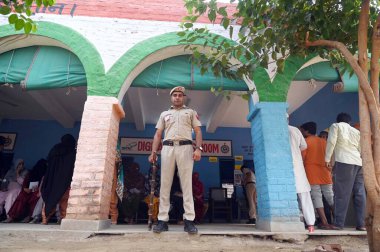 GURUGRAM, INDIA - 25 Mayıs 2024 'te Hindistan' ın Gurugram kentindeki Ghasera köyündeki Lok Sabha seçimlerinin altıncı safhasında polis ve CISF güçleri sandık başına konuşlandırıldı..
