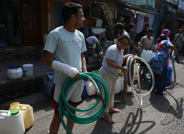 NEW DELHI, INDIA - 31 Mayıs 2024: Delhi Jal Board (DJB) su tankeri sakinleri ve çocukları, Vivekananda Kamp Chanakyapuri 'de yaz aylarında yaşanan bir su krizinin ortasında, 31 Mayıs 2024 tarihinde, Hindistan' ın Yeni Delhi kentinde.