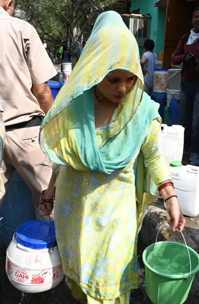 stock image NEW DELHI, INDIA - MAY 31, 2024: Residents and children fill water from a Delhi Jal Board (DJB) water tanker amid a water crisis amid the summer months at Vivekananda Camp Chanakyapuri, on May 31, 2024 in New Delhi, India.