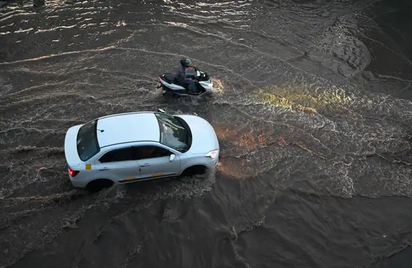 GURUGRAM, INDIA - 27 Temmuz 2024: Araçlar, 27 Temmuz 2024 'te Gurugram, Hindistan' da, İmza Kulesi Chowk yakınlarındaki National Highwway-48 'de yağmurdan sonra su dolu bir alanda yürüdüler.