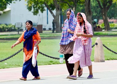 NEW DELHI, INDIA - 20 Mayıs 2024: Sıcak yaz mevsiminde Yeni Delhi, Hindistan 'da 20 Mayıs 2024 tarihinde Kartvaya Yolu çimlerinde sıcak hava dalgasına göğüs geren ziyaretçiler. Hindistan Meteoroloji Bölümü (IMD) hava durumu raporunda şiddetli sıcak hava dalgası koşulları belirtiliyor