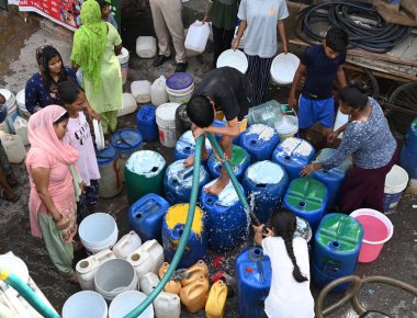 NEW DELHI, INDIA - 29 Mayıs 2024 'te Hindistan' ın Yeni Delhi kentindeki Sanjay Camp Chanakyapuri 'de yaz aylarında yaşanan bir su krizi sırasında, yerliler bir tankerden içme suyu alıyorlar. Artan sıcaklıkla Delhi büyük bir su kriziyle karşı karşıya.