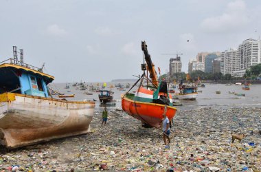 MUMBAI, INDIA - 27 Mayıs 2024 'te Hindistan' ın Mumbai kentindeki Badhwar Park 'ta, bir vinç kullanılarak deniz kıyısından çıkarılan bir tekne..