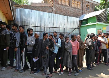 BARAMULLAH, INDIA - 20 Mayıs 2024: İnsanlar 20 Mayıs 2024 tarihinde Hindistan 'ın Baramullah kentindeki Khanpeth bölgesinde yapılan Lok Sabha seçimlerinin beşinci safhasında oy kullanmak için sırada bekliyorlar.