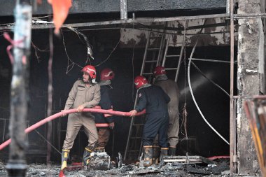 YENİ DELHI, INDIA - 20 Mayıs 2024 tarihinde Yeni Delhi, Hindistan 'da Ajmal Khan Yolu' ndaki bir galeride çıkan yangını kontrol etmeye çalışan Delhi itfaiye yetkilileri. Üst katta mahsur kalan üç kişi kurtarıldı, kıdemli bir polis memuru.