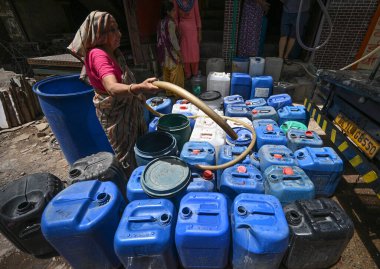 NEW DELHI, INDIA - 30 Mayıs 2024: 30 Mayıs 2024 'te Yeni Delhi, Hindistan' da Anand Parbat 'ta su krizi sırasında Delhi Jal Tahta Tankeri' nden su dolduran insanlar görüldü