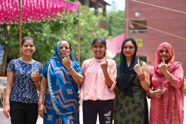 NEW DELHI, INDIA - MAY 25, 2024: Voters show their inked fingers after casting their vote during the sixth phase of Loksabha Elections at a polling station at Saboli on May 25, 2024 in New Delhi, India. clipart