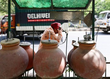 NEW DELHI, INDIA - 30 Mayıs 2024: Yeni Delhi, Hindistan 'da 30 Mayıs 2024' te, IIT Metro İstasyonu yakınlarındaki bir kaldırımda depolanan su şişelerini doldurmak ve susuzluklarını gidermek amacıyla Yeni Delhi, Hindistan 'daki bu sıcak hava dalgasında.