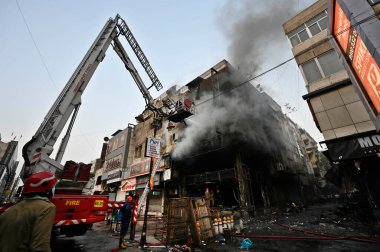 YENİ DELHI, INDIA - 20 Mayıs 2024 tarihinde Yeni Delhi, Hindistan 'da Ajmal Khan Yolu' ndaki bir galeride çıkan yangını kontrol etmeye çalışan Delhi itfaiye yetkilileri. Üst katta mahsur kalan üç kişi kurtarıldı, kıdemli bir polis memuru.