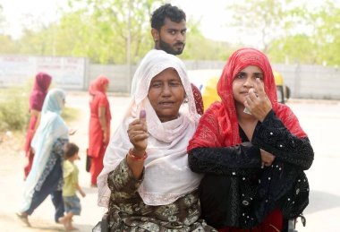 GURUGRAM, INDIA - 25 Mayıs 2024 'te Hindistan' ın Gurugram kentindeki bir köyde Lok Sabha seçimlerinin altıncı safhasında kadınlar mürekkepli parmaklarıyla oy kullandı..