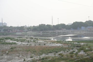 22 Mayıs 2024 'te Yeni Delhi, Hindistan' da Wazirabad, Kuzey Doğu Delhi 'de çöl ve düşük su seviyesi yamuna nehri manzarası. Delhi 'deki su krizi çoğunlukla Yamuna nehrindeki su seviyesinin azalmasından kaynaklanıyor.