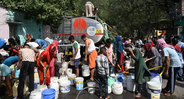 stock image NEW DELHI, INDIA - MAY 31, 2024: Residents and children fill water from a Delhi Jal Board (DJB) water tanker amid a water crisis amid the summer months at Vivekananda Camp Chanakyapuri, on May 31, 2024 in New Delhi, India. 