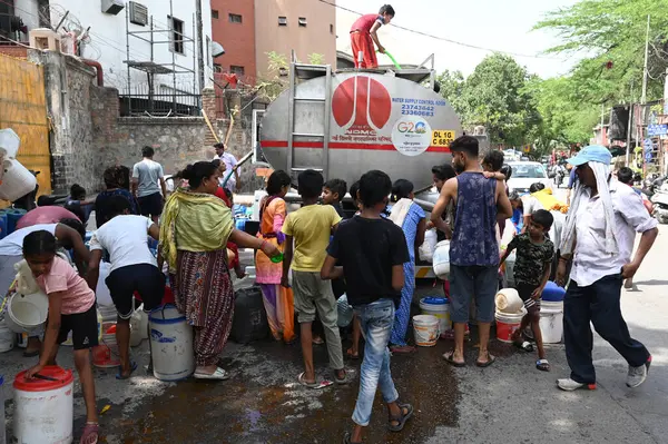 stock image NEW DELHI, INDIA - MAY 29: Locals collect drinking water from a tanker, amid a water crisis amid the summer months, at Sanjay Camp Chanakyapuri on May 29, 2024 in New Delhi, India. With soaring temperature Delhi is facing a huge water crisis