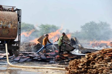 GURUGRAM, INDIA - 21 Nisan 2024 tarihinde Hindistan 'ın Gurugram kentinde, Dwarka otoyolu yakınlarındaki Bajghera köyünde büyük bir yangın çıktı, itfaiye yetkilisi bu olayda kimsenin yaralanmadığını söyledi.. 