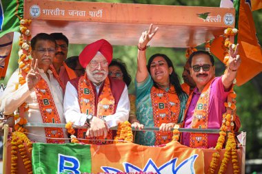 NEW DELHI, INDIA - APRIL 30, 2024: Basuri Swaraj, BJP's Candidate from New Delhi Constituency for upcoming Loksabha Elections seen along Delhi BJP President Virendra Sachdeva and BJP Leader Hardeep Puri during a Roadshow before filing her nomination. clipart