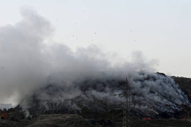 22 Nisan 2024 'te Yeni Delhi, Hindistan' da Ghazipur çöp sahasında yangın çıktı. Dün akşam çöp sahasında yangın çıktı. Alevler çöplüğün ortasına doğru sürüklenirken görüldü. 