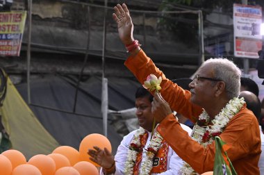 KOLKATA, INDIA - APRIL 9: Bharatiya Janata Party (BJP) Dum Dum Lok Sabha koltuğu adayı Silbhadra Dutta (R) ve Devlet Başkanı Sukanta Majumdar (L) 9 Nisan 2024 tarihinde Kolkata, Hindistan 'da düzenlenen yol gösterisi kampanyasında halka el salladı.  