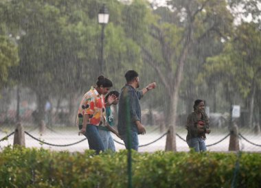 NEW DELHI, INDIA - APRIL 13, 2024: People caught in a dust storm at Kartavya Path, on April 13, 2024 in New Delhi, India. IMD said that due to the influence of several weather systems, including an intense western disturbance. clipart