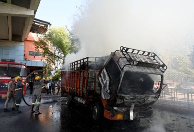 NOIDA, INDIA - 7 Nisan 2024 Noida, Hindistan 'da, Noida City Center metro istasyonu yakınlarındaki bir karton kutuyla dolu bir kamyonda yangını söndüren itfaiye personeli. 