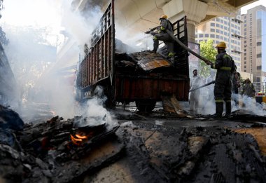 NOIDA, INDIA - 7 Nisan 2024 Noida, Hindistan 'da, Noida City Center metro istasyonu yakınlarındaki bir karton kutuyla dolu bir kamyonda yangını söndüren itfaiye personeli. 