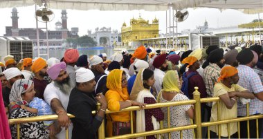  AMRITSAR, INDIA - 13 Nisan 2024 'te Hindistan' ın Amritsar kentindeki Altın Tapınak 'ta düzenlenen Baisakhi festivali vesilesiyle saygılarını sunanlar. 