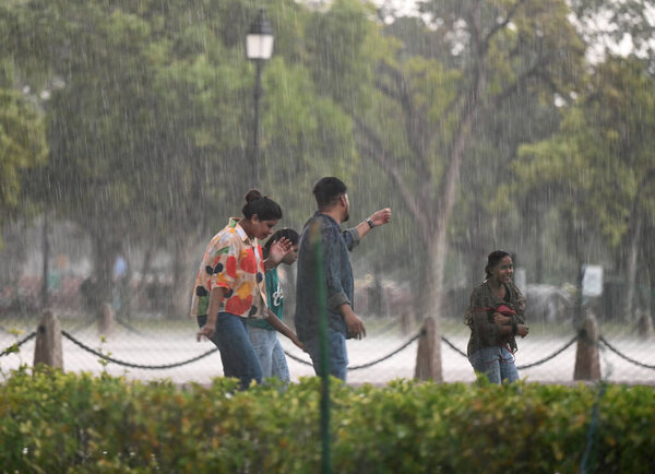 НЬЮ-ДЕЛИ, Индия - 13 апреля 2024 года: Люди попали в пыльный шторм на Картавийском пути, 13 апреля 2024 года в Нью-Дели, Индия. IMD заявила, что из-за влияния нескольких погодных систем, в том числе интенсивных западных волнений.