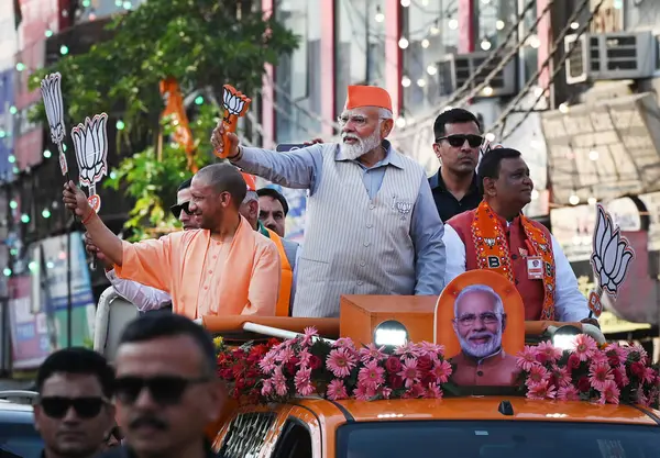 GHAZIABAD, INDIA - 6 Nisan 2024 tarihinde Hindistan 'ın Gaziabad kentinde düzenlenen Lok Sabha seçimleri öncesinde Başbakan Narendra Modi ve Uttar Pradesh CM Yogi Adityanath bir yol gösterisi düzenlediler. Parti sembolü 'lotus' u tutan Başbakan Modi tezahürat yapan kalabalığa el salladı 