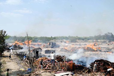 GURUGRAM, INDIA - 21 Nisan 2024 tarihinde Hindistan 'ın Gurugram kentinde, Dwarka otoyolu yakınlarındaki Bajghera köyünde büyük bir yangın çıktı, itfaiye yetkilisi bu olayda kimsenin yaralanmadığını söyledi.. 