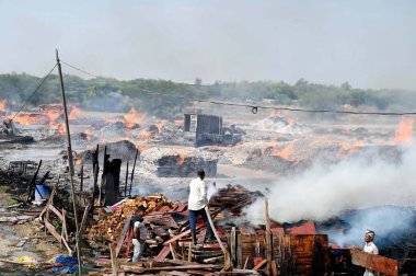 GURUGRAM, INDIA - 21 Nisan 2024 tarihinde Hindistan 'ın Gurugram kentinde, Dwarka otoyolu yakınlarındaki Bajghera köyünde büyük bir yangın çıktı, itfaiye yetkilisi bu olayda kimsenin yaralanmadığını söyledi.. 