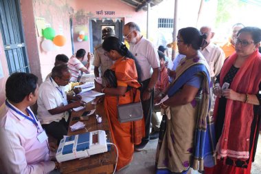 BHAGALPUR, INDIA - 26 Nisan 2024 tarihinde Hindistan 'ın Bhagalpur kentinde yapılan bir sandık kabininde Lok Sabha seçiminin ikinci safhasında oy kullanmak için sırada bekleyenler.  