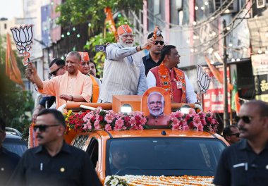 GHAZIABAD, INDIA - 6 Nisan 2024 tarihinde Hindistan 'ın Gaziabad kentinde düzenlenen Lok Sabha seçimleri öncesinde Başbakan Narendra Modi ve Uttar Pradesh CM Yogi Adityanath bir yol gösterisi düzenlediler. Parti sembolü 'lotus' u tutan Başbakan Modi tezahürat yapan kalabalığa el salladı 