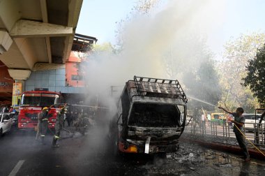 NOIDA, INDIA - 7 Nisan 2024 Noida, Hindistan 'da, Noida City Center metro istasyonu yakınlarındaki bir karton kutuyla dolu bir kamyonda yangını söndüren itfaiye personeli. 