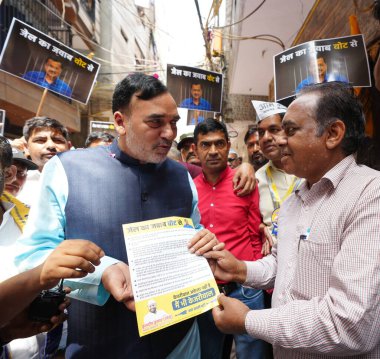 New Delhi, India- April 09, 2024: AAP Delhi State Convenor Gopal Rai, along with Party East Delhi Candidate Kudeep Kumar, and Party Workers Jail Ka Jawab Vote Se door to door campaign at Vishwas Nagar, Shahdara  on April 9, 2024 in New Delhi clipart