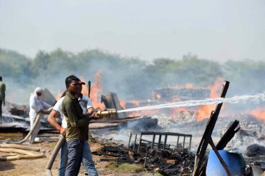GURUGRAM, INDIA - 21 Nisan 2024 tarihinde Hindistan 'ın Gurugram kentinde, Dwarka otoyolu yakınlarındaki Bajghera köyünde büyük bir yangın çıktı, itfaiye yetkilisi bu olayda kimsenin yaralanmadığını söyledi.. 