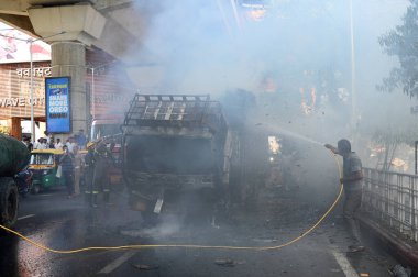 NOIDA, INDIA - 7 Nisan 2024 Noida, Hindistan 'da, Noida City Center metro istasyonu yakınlarındaki bir karton kutuyla dolu bir kamyonda yangını söndüren itfaiye personeli. 