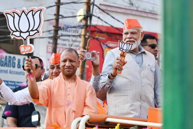 GHAZIABAD, INDIA - 6 Nisan 2024 tarihinde Hindistan 'ın Gaziabad kentinde düzenlenen Lok Sabha seçimleri öncesinde Başbakan Narendra Modi ve Uttar Pradesh CM Yogi Adityanath bir yol gösterisi düzenlediler. Parti sembolü 'lotus' u tutan Başbakan Modi tezahürat yapan kalabalığa el salladı 