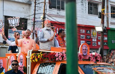 GHAZIABAD, INDIA - 6 Nisan 2024 tarihinde Hindistan 'ın Gaziabad kentinde düzenlenen Lok Sabha seçimleri öncesinde Başbakan Narendra Modi ve Uttar Pradesh CM Yogi Adityanath bir yol gösterisi düzenlediler. Parti sembolü 'lotus' u tutan Başbakan Modi tezahürat yapan kalabalığa el salladı 