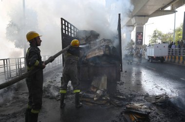 NOIDA, INDIA - 7 Nisan 2024 Noida, Hindistan 'da, Noida City Center metro istasyonu yakınlarındaki bir karton kutuyla dolu bir kamyonda yangını söndüren itfaiye personeli. 