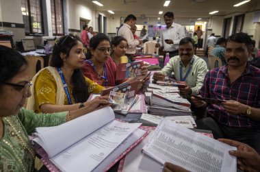 MUMBAI, INDIA - 2 Nisan 2024 tarihinde Hindistan 'ın Mumbai kentinde yapılan Ghatkopar Seçim Komisyonu ofisinde Lok Sabha Seçimleri öncesinde kurye için yeni uygulanan seçmen kimlik kartlarını kısa listeye alan seçim memurları. 