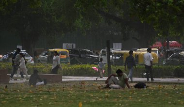 NEW DELHI, INDIA - 13 Nisan 2024: İnsanlar 13 Nisan 2024 tarihinde Yeni Delhi, Hindistan 'da Kartavya Yolu' nda bir toz fırtınasına yakalandı. IMD 'nin dediğine göre, Batı' da yaşanan yoğun bir karışıklık da dahil olmak üzere birkaç hava sisteminin etkisi nedeniyle....
