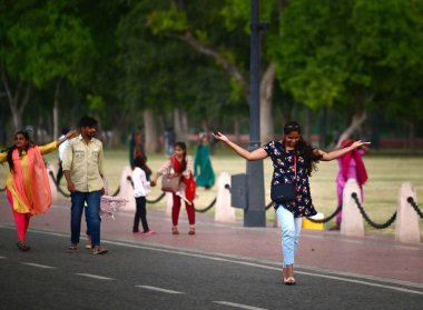 NEW DELHI, INDIA - 13 Nisan 2024 'te Yeni Delhi, Hindistan' da Kartavaya Yolu 'nda bulutlar ve güçlü rüzgar esintisi eserken ziyaretçiler görülüyor. IMD, çeşitli hava sistemlerinin etkisinden dolayı