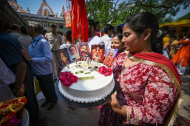 NEW DELHI, INDIA - APRIL 23, 2024:  A devotee seen carrying a birthday cake on the occasion of Hanuman Jayanti as Massive crowds of Devotees emerged at Hanuman Temple Connaught Place  on April 23, 2024 in New Delhi, India. clipart