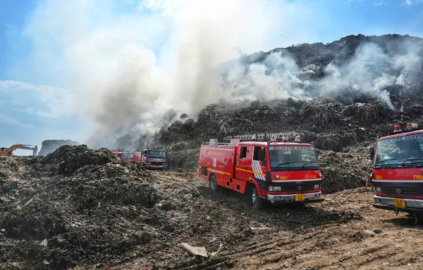 stock image NEW DELHI, INDIA - APRIL 22, 2024:  Firemen working round the clock to douse the fire at Gazipur Landfill area in the morning on April 22, 2024 in New Delhi, India.  