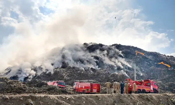 stock image NEW DELHI, INDIA - APRIL 22, 2024:  Firemen working round the clock to douse the fire at Gazipur Landfill area in the morning on April 22, 2024 in New Delhi, India.  